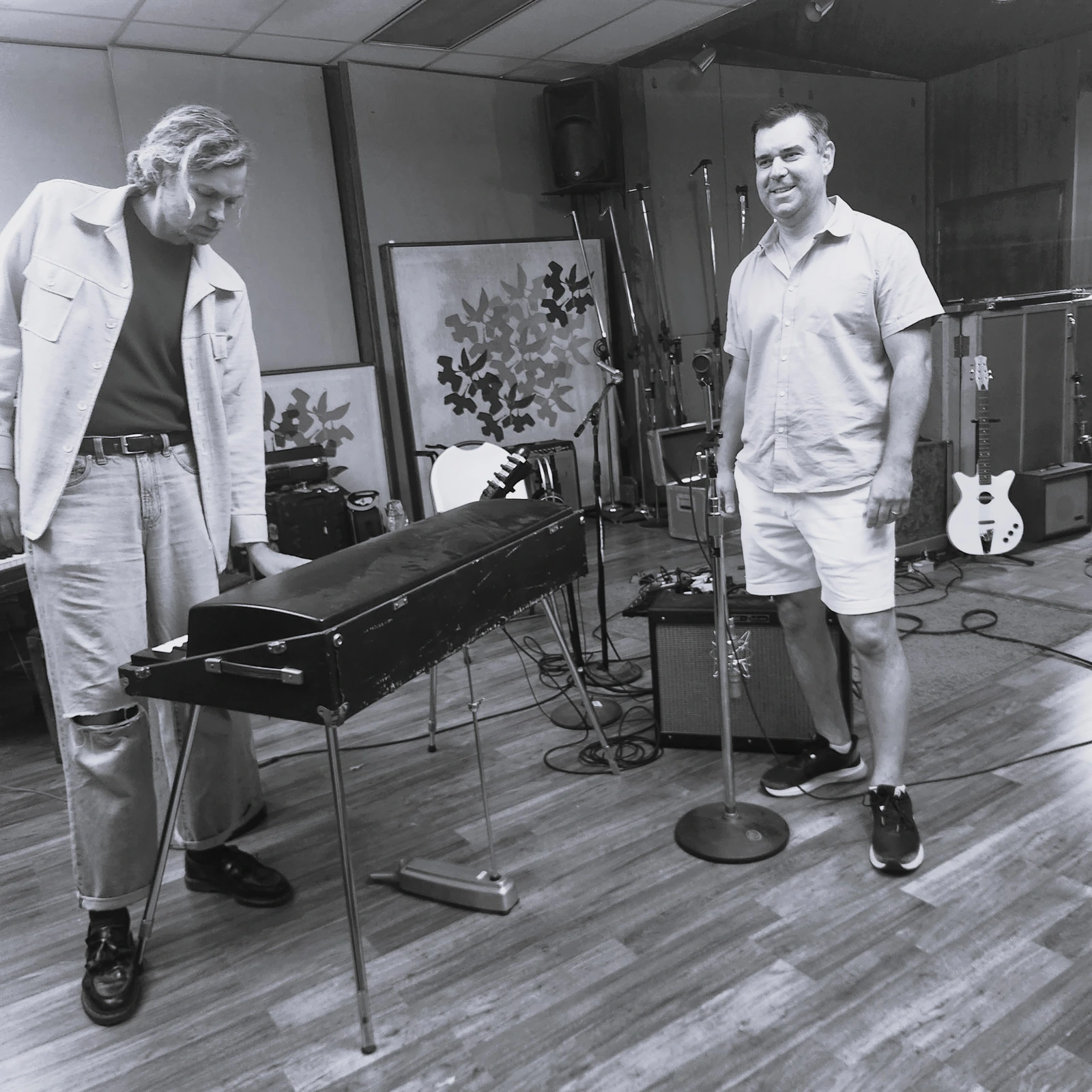 Two musicians beside a keyboard in the recording studio